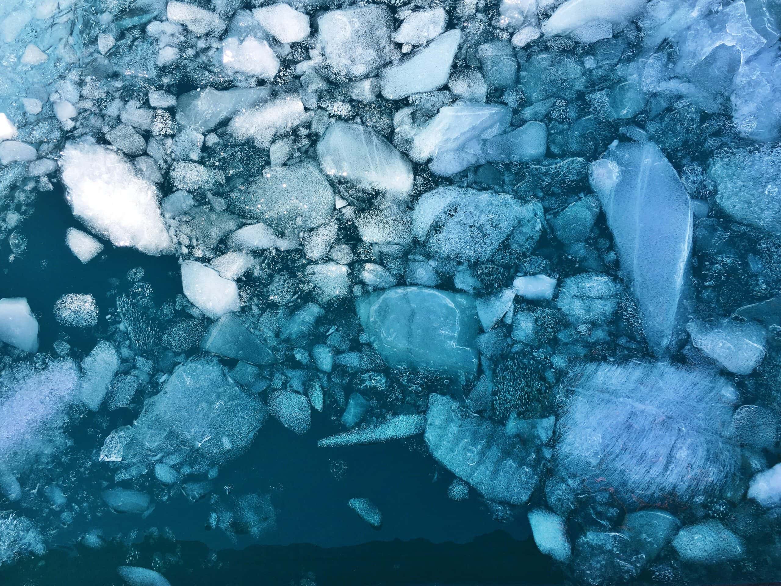 Large ice chunks float on top of the water - aerial view